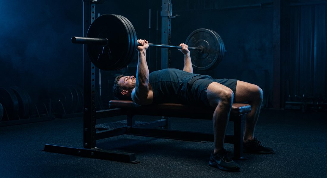 Athlete pressing a barbell on a bench